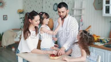 快乐的家庭在厨房，妈妈，爸爸和女儿吃草莓，慢动作